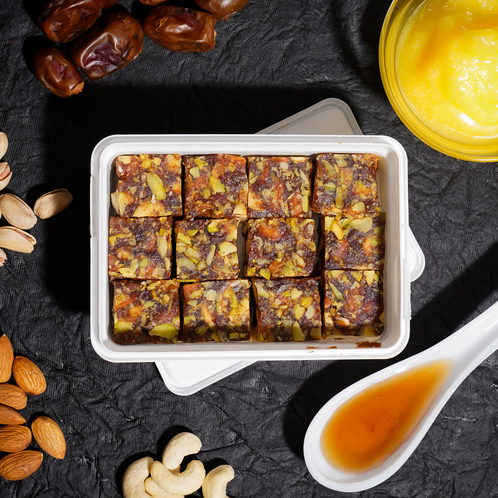 Rakhi Gift Hamper featuring a collection of dry fruits, dates, and sweets in an elegant box.